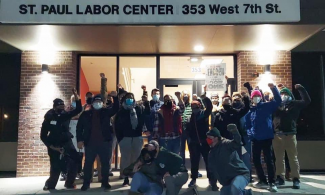Workers raise a fist in salute after defending the regional labor center